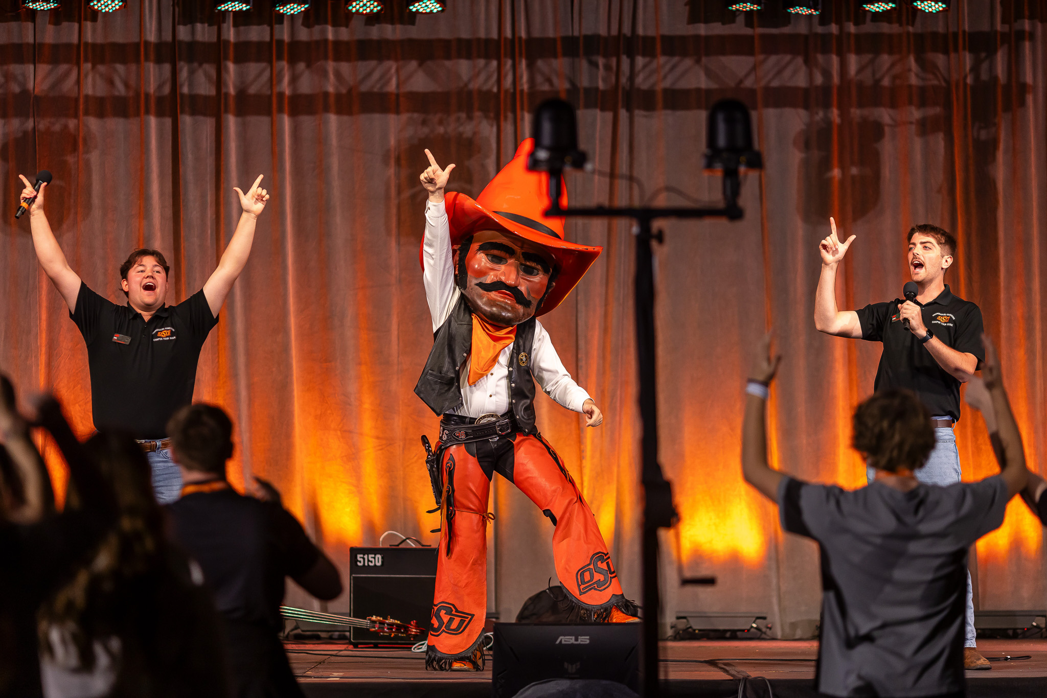 Campus tour guides and Pistol Pete teach future OSU students OSU chants during an event.