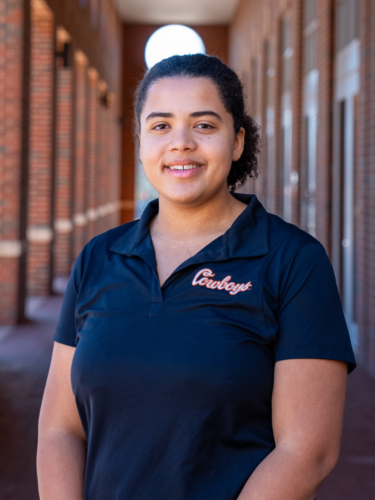 student posing behind ConocoPhillips OSU Alumni Center
