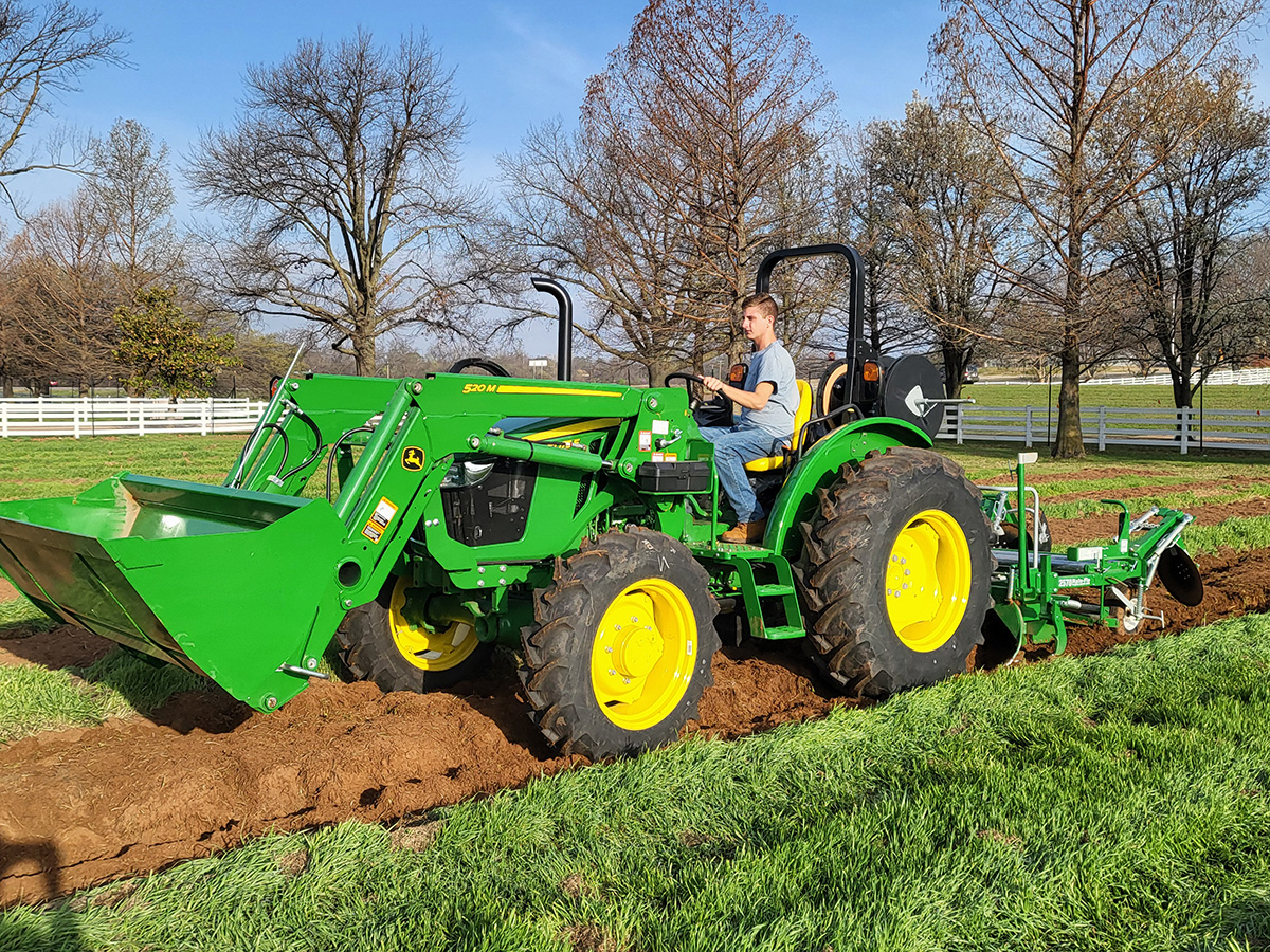 Student worker on tractor working on Student Farm